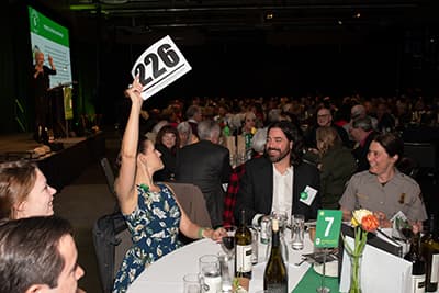 Participant raises her bidding card during the live auction