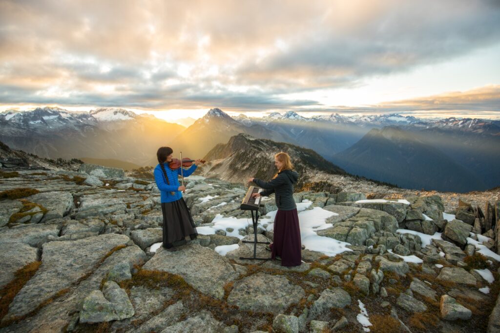 The musical mountaineers perform on a mountain at sunset