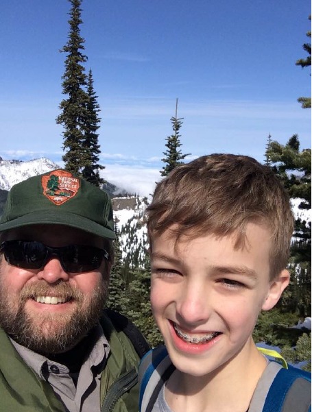 Dean poses in front of mountains with a young boy