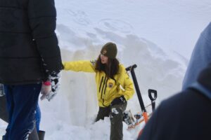 A student examines snow levels on a field trip to the park