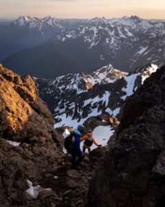 Hikers climb down a rocky peak in the backcountry in Olympic National Park