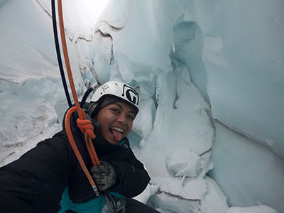 Kacee smiles from inside a crevasse