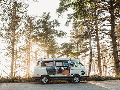 A PacWesty camper van parks amongst the trees