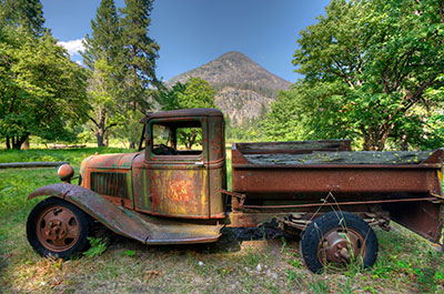 A truck with rust in front of a mountain