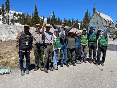 WNPF staff, NPS staff, and Amazon@Outdoors staff smile for a group photo outside of Paradise Inn