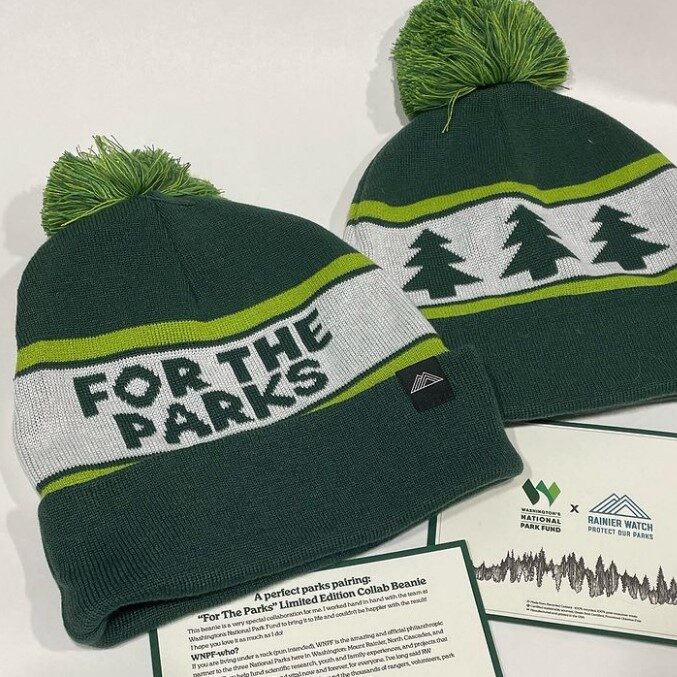 two green striped beanies that say "For The Parks" and has a graphic of three trees.