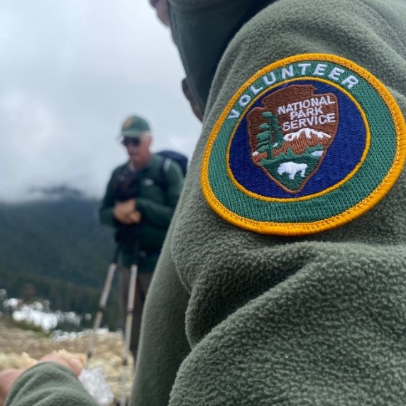 An up close photo of a NPS volunteer patch on a green fleece.