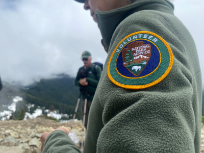 An up close photo of an NPS volunteer patch on a green fleece jacket.