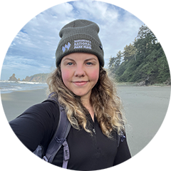 A photo of a woman wearing a green beanie at the beach